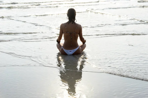 Fille qui pratique le yoga sur la plage — Photo