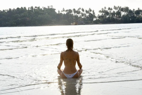 Fille qui pratique le yoga sur la plage — Photo
