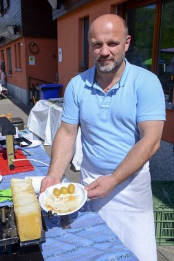 Adam raclette Mugena İsviçre tarih itibariyle bir kısmını hazırlanıyor