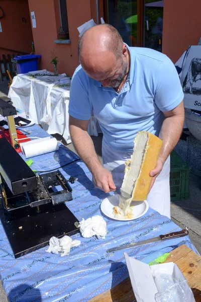 Uomo che prepara una porzione di raclette a Mugena in Svizzera — Foto Stock