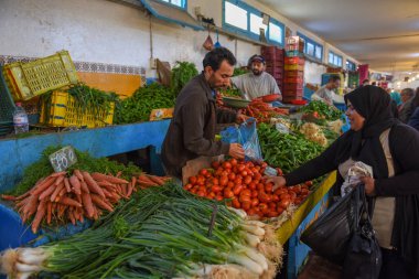Sousse Medina 'daki pazarda sebze satan insanlar. 