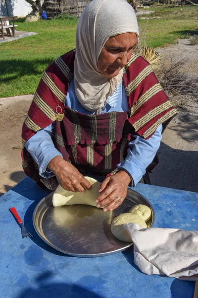 Gammel dame som baker et tradisjonelt arabbrød på Sousse i Tunisia – stockfoto