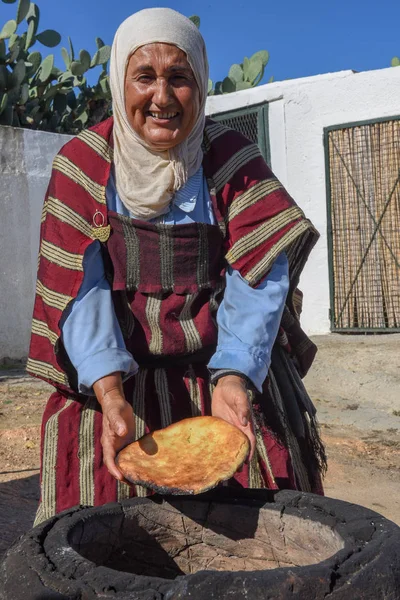 Velha senhora assar um pão árabe tradicional em Sousse, na Tunísia — Fotografia de Stock