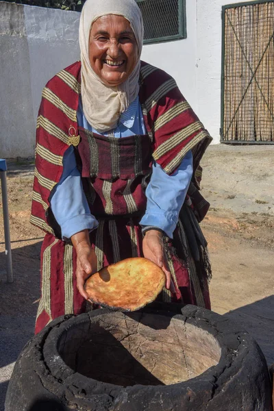 Velha senhora assar um pão árabe tradicional em Sousse, na Tunísia — Fotografia de Stock