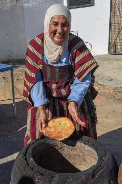 Velha senhora assar um pão árabe tradicional em Sousse, na Tunísia — Fotografia de Stock
