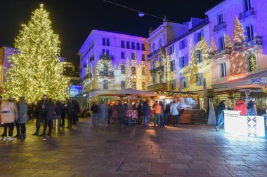 İnsanlar İsviçre, Lugano 'da noel pazarında alışveriş yapıyorlar.