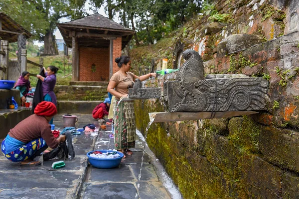 Women washing clothes at the fountain of Bandipur village on Nep — Stockfoto