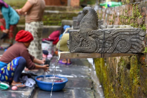 Women washing clothes at the fountain of Bandipur village on Nep — Stockfoto