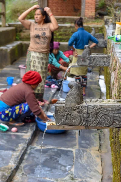 Women washing clothes at the fountain of Bandipur village on Nep — Stockfoto