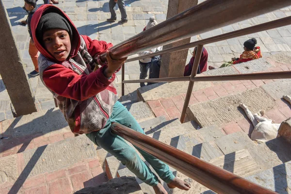 Niño jugando en las escaleras de un templo en la plaza Durban en Kathmand — Foto de Stock