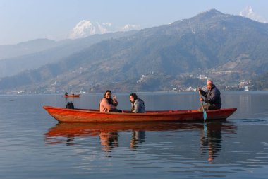 Pokhara, Nepal - 12 Ocak 2020: Nepal 'deki Pokhara gölünde insanlar bir kanoda hareket ediyor