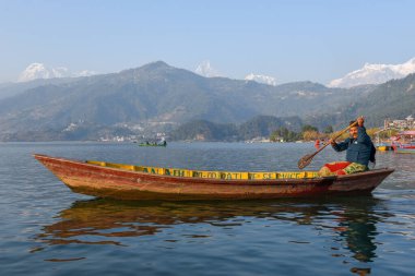 Pokhara, Nepal - 12 Ocak 2020: Nepal 'deki Pokhara gölünde insanlar bir kanoda hareket ediyor