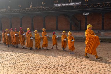 Bhaktapur, Nepal - 28 Ocak 2020: Nepal 'deki Bhaktapur' da sabah sadakalarında yürüyen genç Budist rahipler