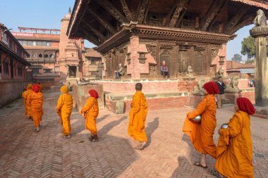 Bhaktapur, Nepal - 28 Ocak 2020: Nepal 'deki Bhaktapur' da sabah sadakalarında yürüyen genç Budist rahipler
