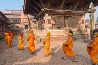 Bhaktapur, Nepal - 28 Ocak 2020: Nepal 'deki Bhaktapur' da sabah sadakalarında yürüyen genç Budist rahipler