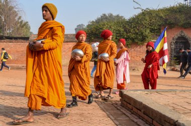 Bhaktapur, Nepal - 28 Ocak 2020: Nepal 'deki Bhaktapur' da sabah sadakalarında yürüyen genç Budist rahipler