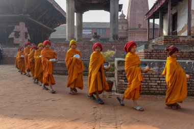 Bhaktapur, Nepal - 28 Ocak 2020: Nepal 'deki Bhaktapur' da sabah sadakalarında yürüyen genç Budist rahipler