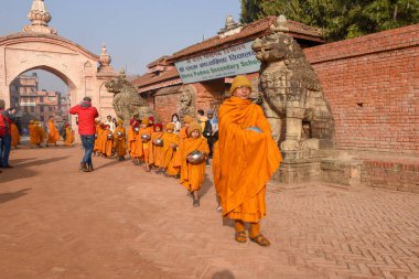 Bhaktapur, Nepal - 28 Ocak 2020: Nepal 'deki Bhaktapur' da sabah sadakalarında yürüyen genç Budist rahipler