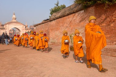 Bhaktapur, Nepal - 28 Ocak 2020: Nepal 'deki Bhaktapur' da sabah sadakalarında yürüyen genç Budist rahipler
