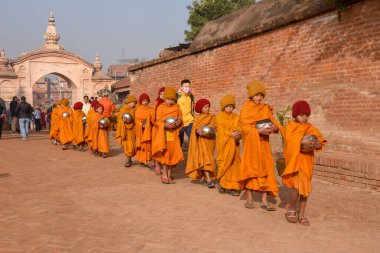 Bhaktapur, Nepal - 28 Ocak 2020: Nepal 'deki Bhaktapur' da sabah sadakalarında yürüyen genç Budist rahipler