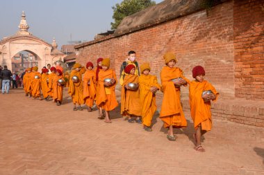 Bhaktapur, Nepal - 28 Ocak 2020: Nepal 'deki Bhaktapur' da sabah sadakalarında yürüyen genç Budist rahipler