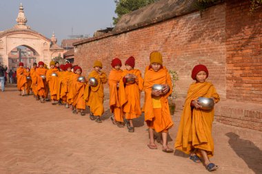 Bhaktapur, Nepal - 28 Ocak 2020: Nepal 'deki Bhaktapur' da sabah sadakalarında yürüyen genç Budist rahipler