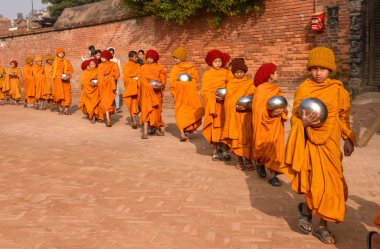 Bhaktapur, Nepal - 28 Ocak 2020: Nepal 'deki Bhaktapur' da sabah sadakalarında yürüyen genç Budist rahipler