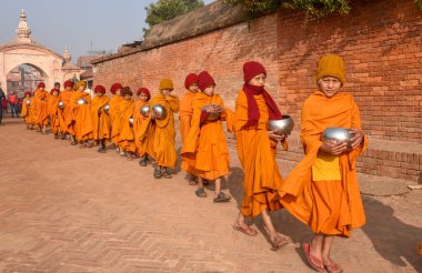 Bhaktapur, Nepal - 28 Ocak 2020: Nepal 'deki Bhaktapur' da sabah sadakalarında yürüyen genç Budist rahipler