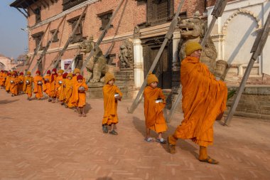 Bhaktapur, Nepal - 28 Ocak 2020: Nepal 'deki Bhaktapur' da sabah sadakalarında yürüyen genç Budist rahipler