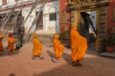 Bhaktapur, Nepal - 28 Ocak 2020: Nepal 'deki Bhaktapur' da sabah sadakalarında yürüyen genç Budist rahipler