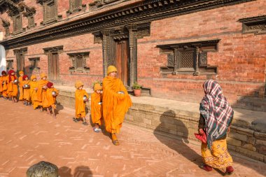 Bhaktapur, Nepal - 28 Ocak 2020: Nepal 'deki Bhaktapur' da sabah sadakalarında yürüyen genç Budist rahipler