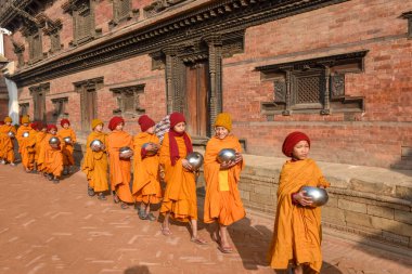 Bhaktapur, Nepal - 28 Ocak 2020: Nepal 'deki Bhaktapur' da sabah sadakalarında yürüyen genç Budist rahipler