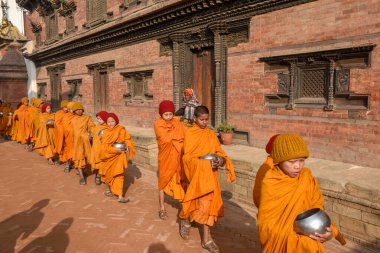 Bhaktapur, Nepal - 28 Ocak 2020: Nepal 'deki Bhaktapur' da sabah sadakalarında yürüyen genç Budist rahipler