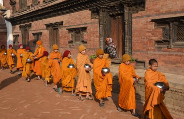 Bhaktapur, Nepal - 28 Ocak 2020: Nepal 'deki Bhaktapur' da sabah sadakalarında yürüyen genç Budist rahipler