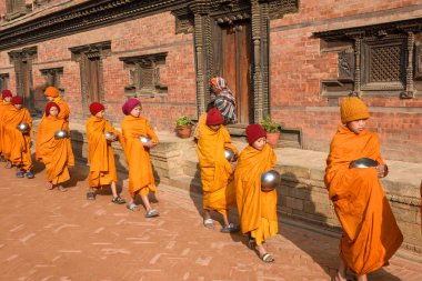 Bhaktapur, Nepal - 28 Ocak 2020: Nepal 'deki Bhaktapur' da sabah sadakalarında yürüyen genç Budist rahipler