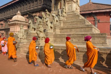 Bhaktapur, Nepal - 28 Ocak 2020: Nepal 'deki Bhaktapur' da sabah sadakalarında yürüyen genç Budist rahipler