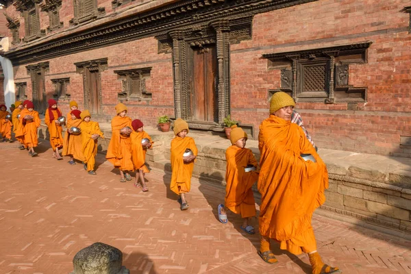 Bhaktapur, Nepal - 28 Ocak 2020: Nepal 'deki Bhaktapur' da sabah sadakalarında yürüyen genç Budist rahipler