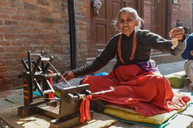 Bhaktapur, Nepal - 28 Ocak 2020: Nepal 'de Bhaktapur' da yün ören yaşlı kadın