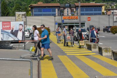Lugano, İsviçre - 9 Mayıs 2020: İsviçre 'deki Lugano' da insanlar Coronavirus (COVID-19) nedeniyle süpermarketin önünde kuyruğa giriyorlar