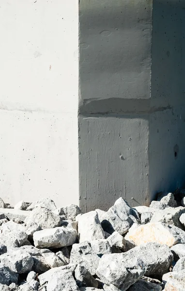 Rock rubble by corners of smooth vertical wall. — Stock Photo, Image