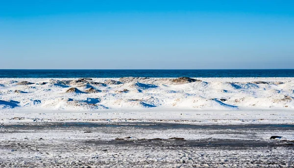 Frozen dunes on beach against water and sky. — Stock Photo, Image