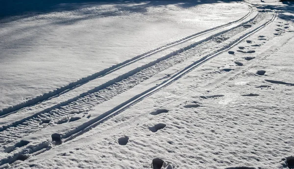 Skoterleder och fotavtryck på snö. — Stockfoto
