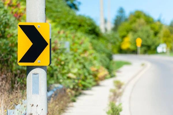 Chevron road sign indicating right turn. Royalty Free Stock Images