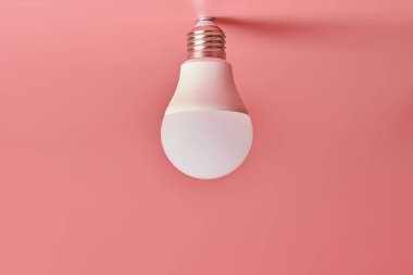 Enerji tasarrufu ampulü, kopyalama alanı, pembe zemin. Asgari fikir kavramı.