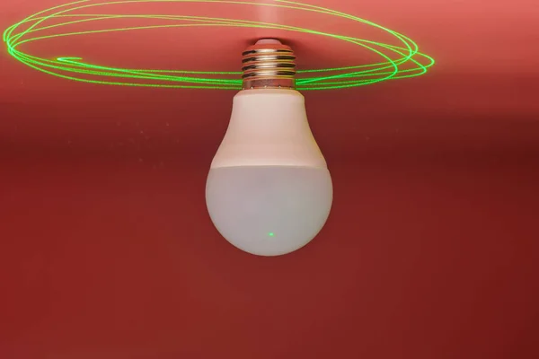 Glödlampa och grön laserstråle runt, energibesparing. Minimalt idékoncept. — Stockfoto