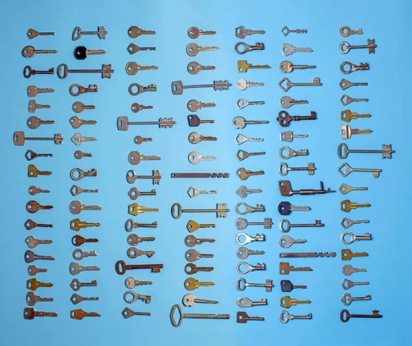 Billentyűk beállított kék háttér. Ajtózár gombok és széfek az ingatlan biztonság és a ház védelmét. Különböző antik és új típusú kulcsok. — Stock Fotó