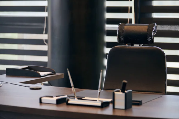 Business office workplace. Work place for chief, boss or other employees. Table and comfortable chair. Light through the half open blinds