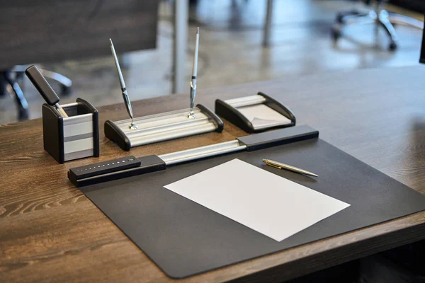 Moderní kancelářská pracoviště ve velké společnosti. Pohodlný pracovní stůl s papírnictví, kožené křeslo. Šéf, šéf, vedoucí pracoviště společnosti. — Stock fotografie