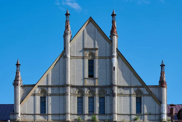 Forlatt utvendig bygning. En fasade av en tidligere bygning av hvit murstein. Dagslys . – stockfoto