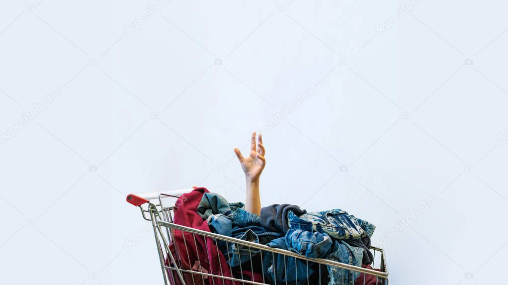 Shopaholic concept. Female hand sticks out of shopping cart